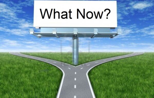Split in the road with sign that says What Now?