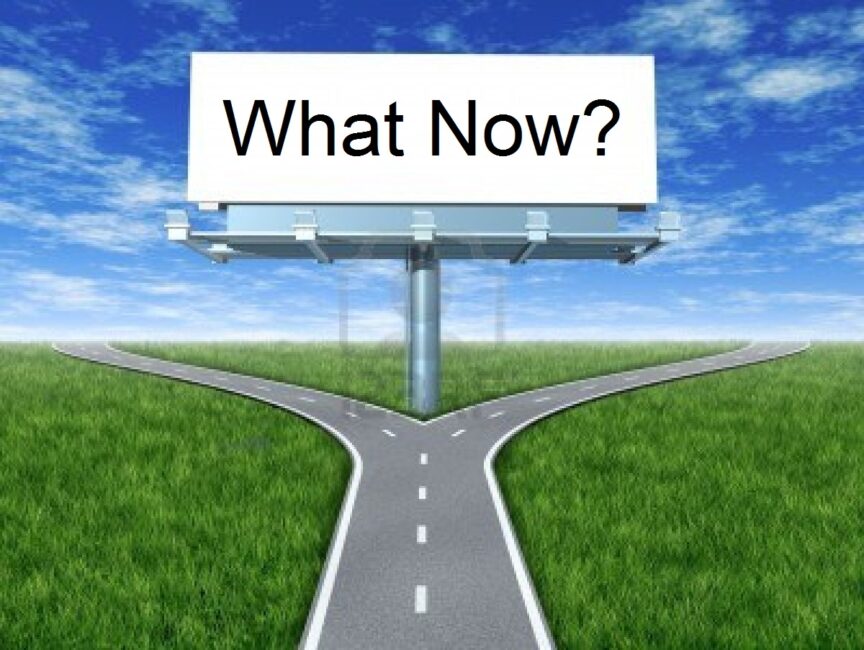 Split in the road with sign that says What Now?