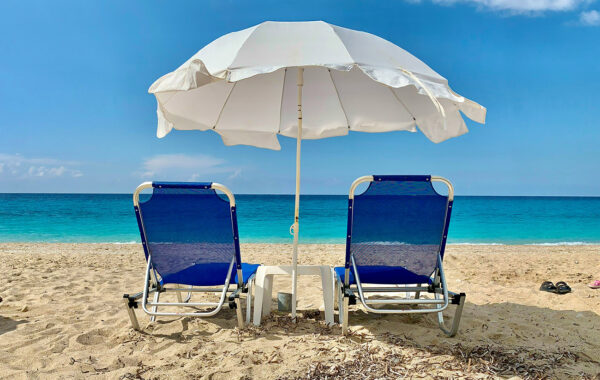 Summertime beach scene with chairs and umbrella
