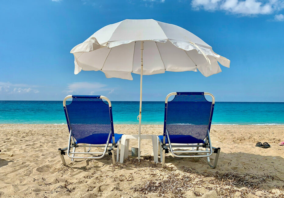 Summertime beach scene with chairs and umbrella